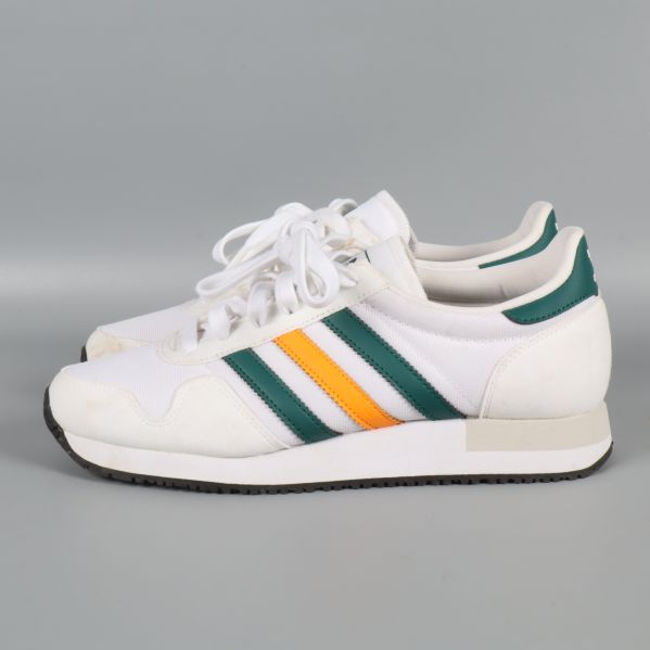 Sneakers från sidan liggande på grått underlag