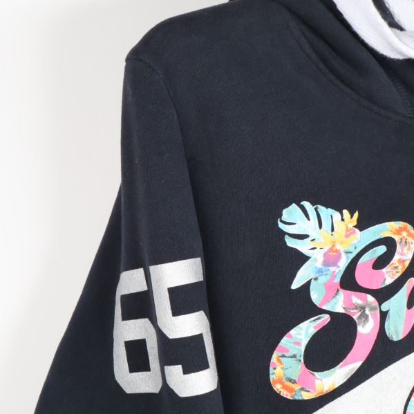 Ärmdetalj med nummer 65 i vitt tryck