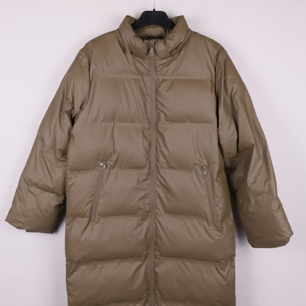 Framifrån beige lång pufferjacka med dragkedjor