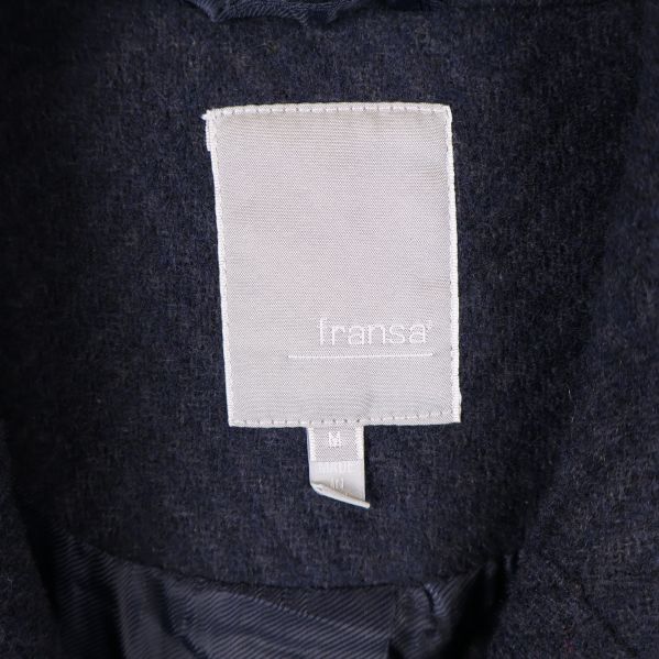 Närbild på vit varumärkestagg med texten fransa
