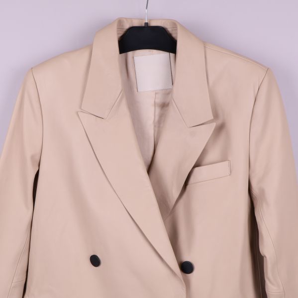 Närbild på överdelen av beige skinnkavaj med krage