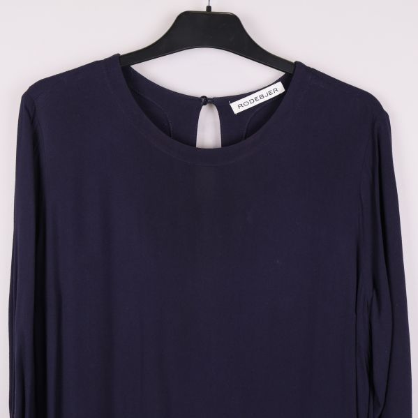 Närbild på överdel av mörkblå klänning med rund hals