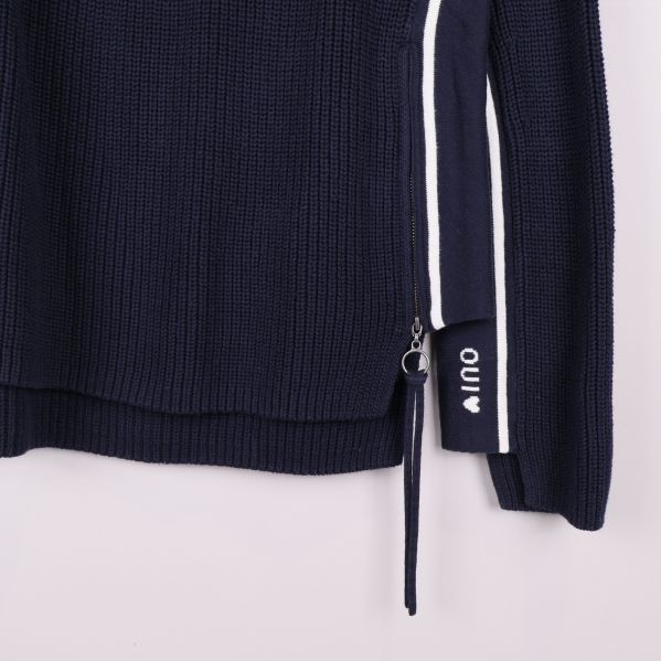 Detalj av dragkedja och logga på tröjans sida