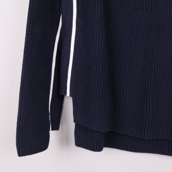 Närbild av tröjans nedre del och arm med vit rand