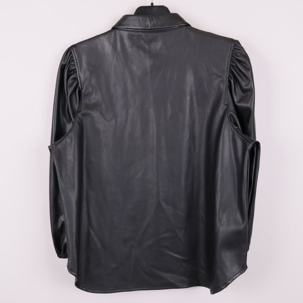 Baksida av svart blus i konstläder på galge