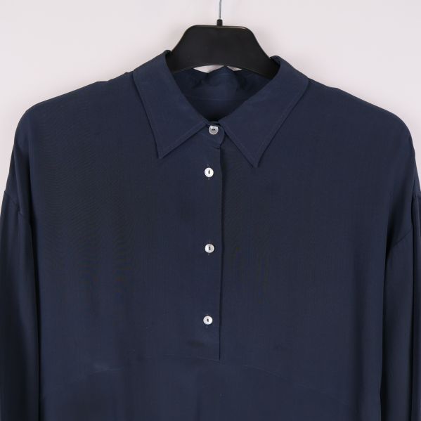 Närbild av krage och knappar på mörkblå blus