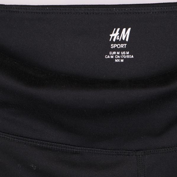 Närbild på H&M Sport logga i tightsens midja