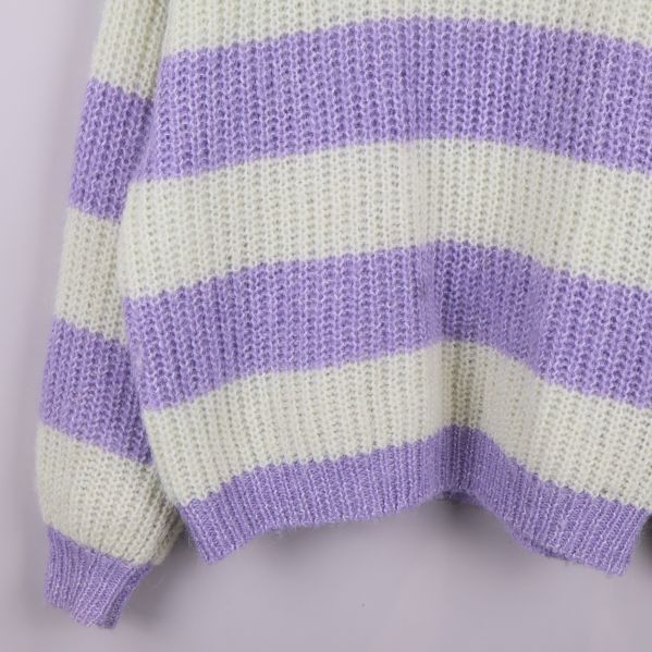 Närbild på nederdelen av lila och vitrandig stickad tröja