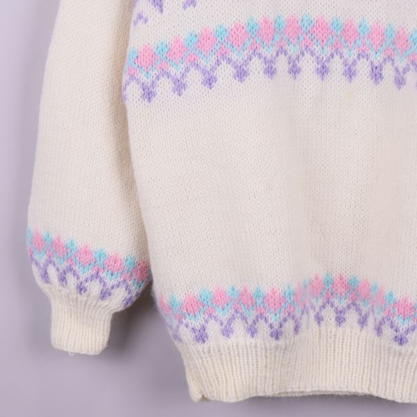 Ärm och nederkant av stickad tröja, ribbad mudd syns