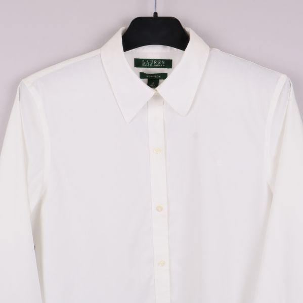 Närbild på övre del av vit skjorta med krage och knappslå