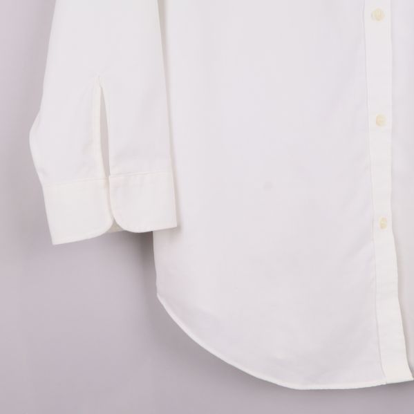 Ärmslut med manschett och knapp på vit skjorta