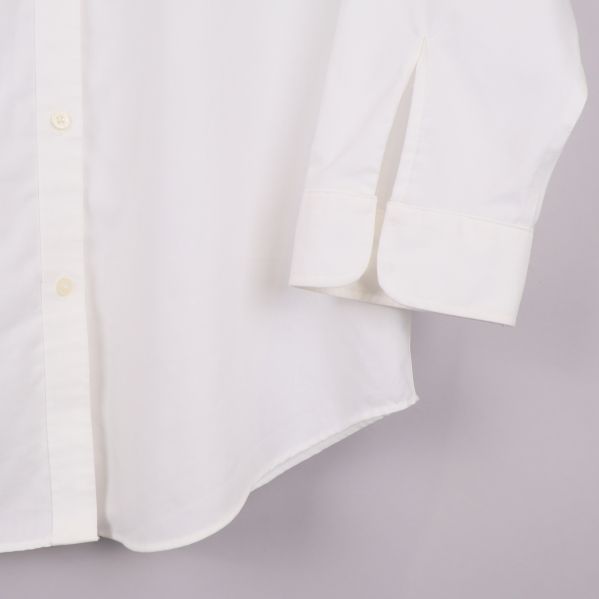 Nedre del av skjorta visar rundad fåll och manschett