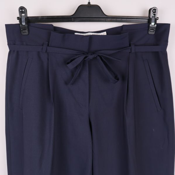 Närbild på midja och knytskärp på mörkblå dressbyxa