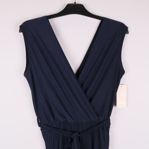 Närbild av djup v-ringning och elastisk midja på byxdress