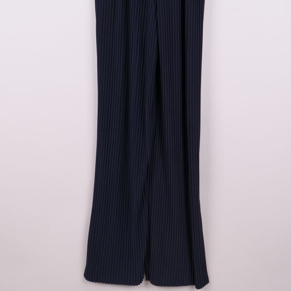 Närbild av plisserade, vida ben på byxdress