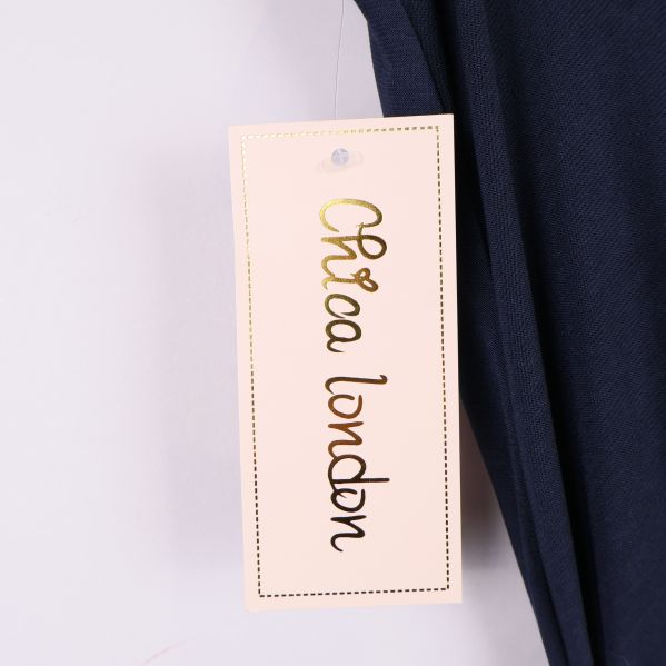 Etikett med texten Chica London i guld