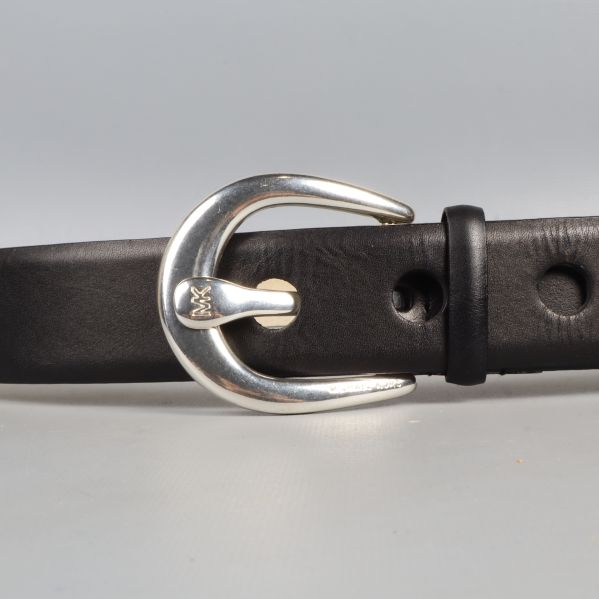 Närbild på bältets silverfärgade spänne och hål