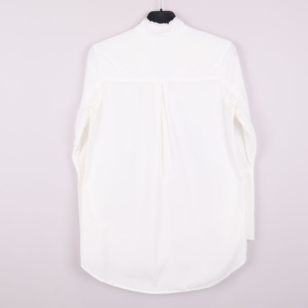 Baksidan av vit långärmad skjorta med veck