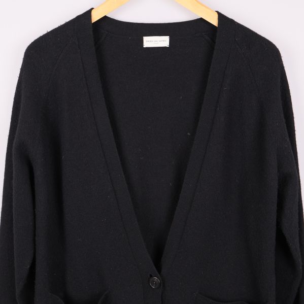 Detalj av V-ringning och knappar på svart kofta