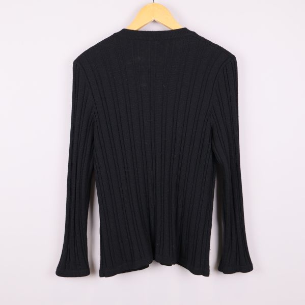 Baksidan av svart ribbstickad kofta på galge