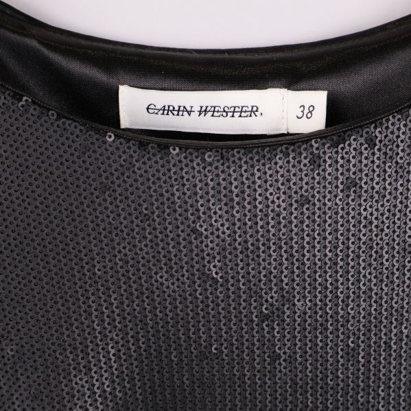 Närbild av halsringning och Carin Wester-etikett på topp