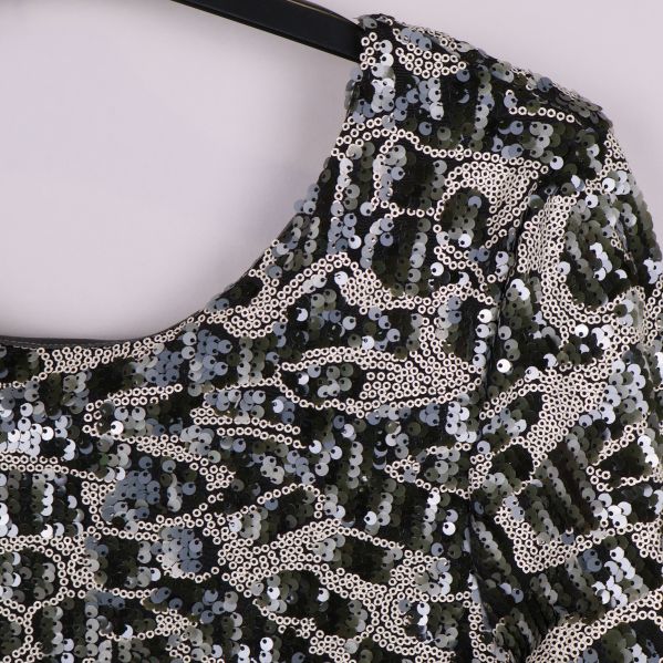 Närbild på paljettytan och halsringningen