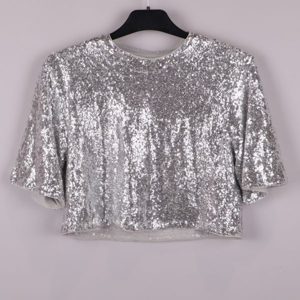 Framsidan av silvrig paljettopp