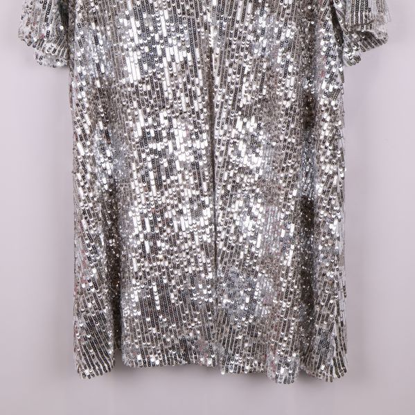 Nedre del av tunikan med täckande silverpaljetter och rak fåll
