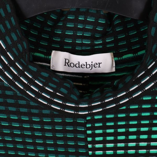 Närbild på Rodebjer-loggan i nacken på klänningen