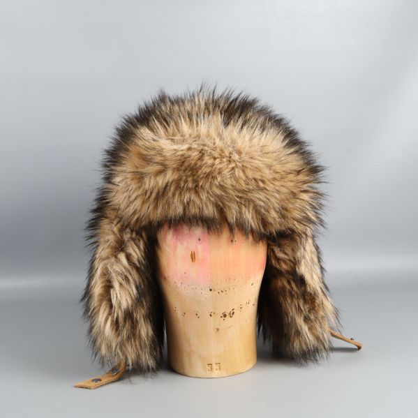 Fuskpälsmössa fotograferad rakt framifrån på trähuvud