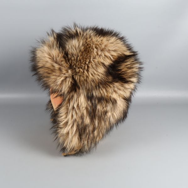 Fuskpälsmössa fotograferad från andra sidan på trähuvud