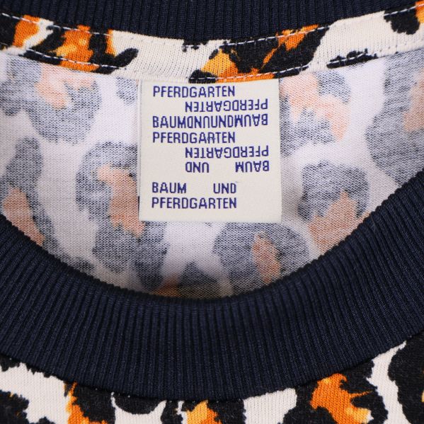 Närbild på etikett med Baum und Pferdgarten-logga i halsen