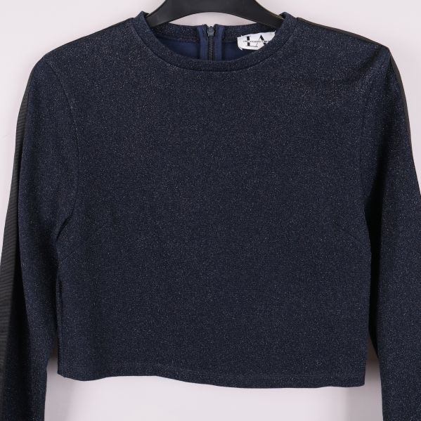 Närbild på framsidan av glittertoppen och halsringningen