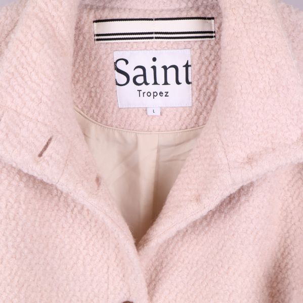 Detaljbild på etikett inuti kappan med texten Saint Tropez