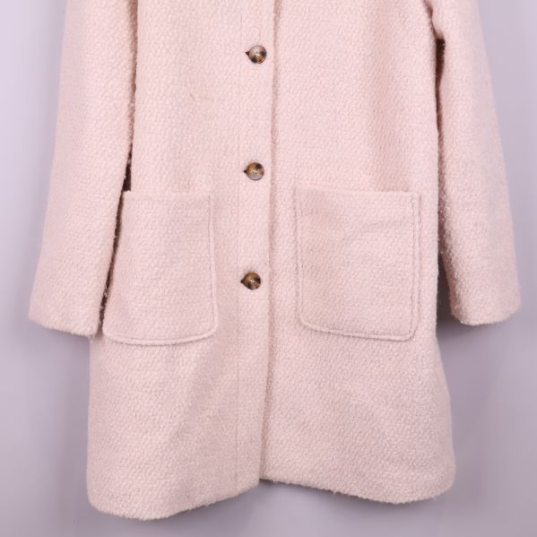 Närbild på stora framfickor och nederdel av kappa