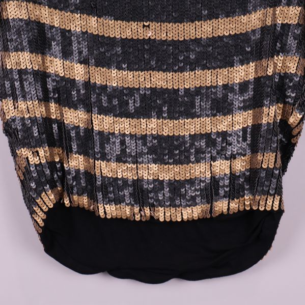 Nederkant på topp med svart tyg och paljettränder ovanför