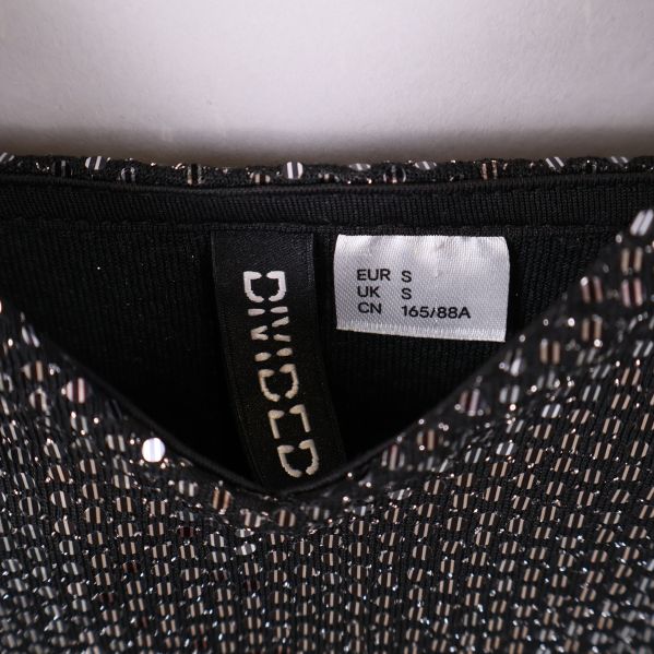 Närbild på storleksetikett med H&M Divided-märke