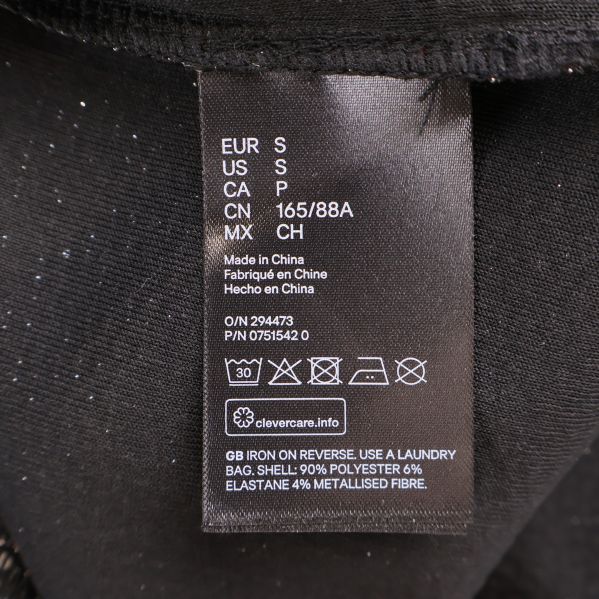 Materialetikett visar 90% polyester, 6% elastan, 4% metallfiber