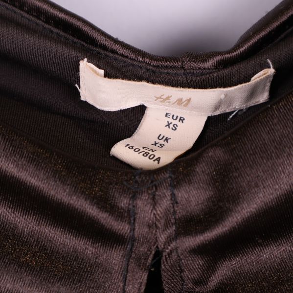 Närbild på H&M-etikett i brun glansig topp