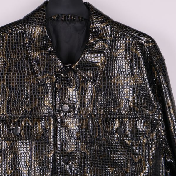 Närbild på axlar och bröstfickor med ormmönster