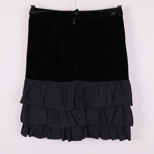 Baksidan av svart sammetskjol med volangkant