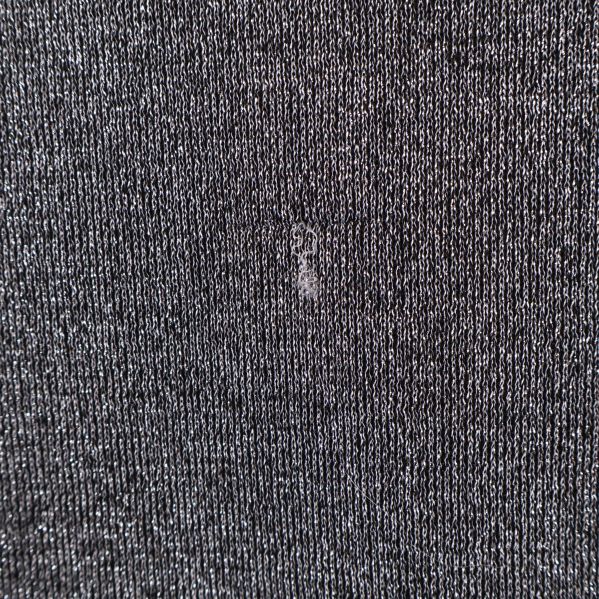 Närbild lös tråd och litet slitage