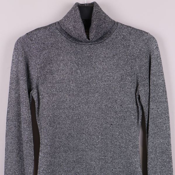 Övre del av glittrig polotröja med hög krage