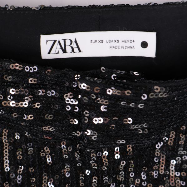 Närbild på Zara-etikett och paljetter i midjan