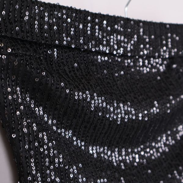 Närbild på överkant av svart paljettopp