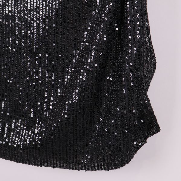 Närbild på nedre delen av svart paljettopp