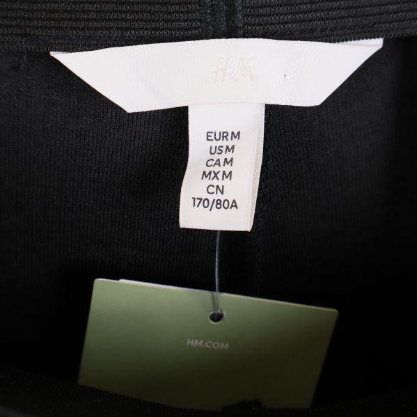 Närbild på H&M-etikett med storlek M i tightsen