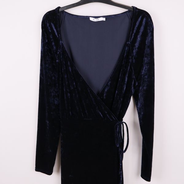 Närbild på omlottklänningens överdel och v-ringning