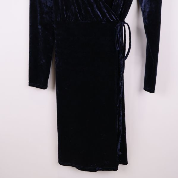 Nedre delen av svart sammetsklänning med knytband i midjan