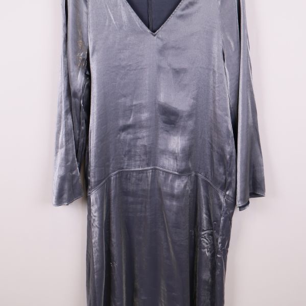 Mittenparti av glansig långärmad klänning i silverblå ton med sömdetalj